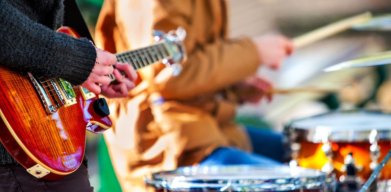 Festival music band. Hands playing on percussion instruments in city park . Drums with sticks closeup.